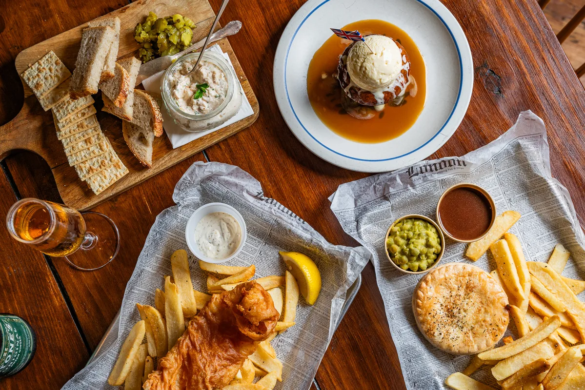 A pint of ale beside a plate of chips